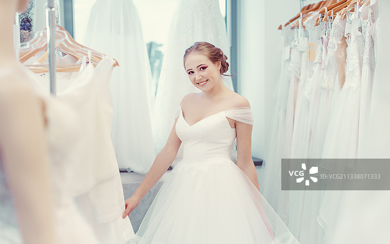 年轻女子在婚礼商店为新娘穿的衣服图片素材