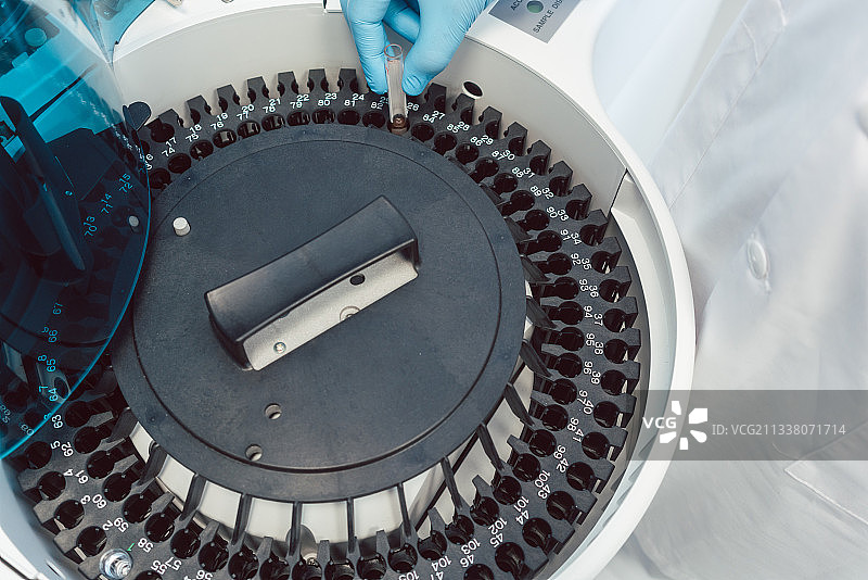 实验室技术人员在离心机上装载人血来分析图片素材