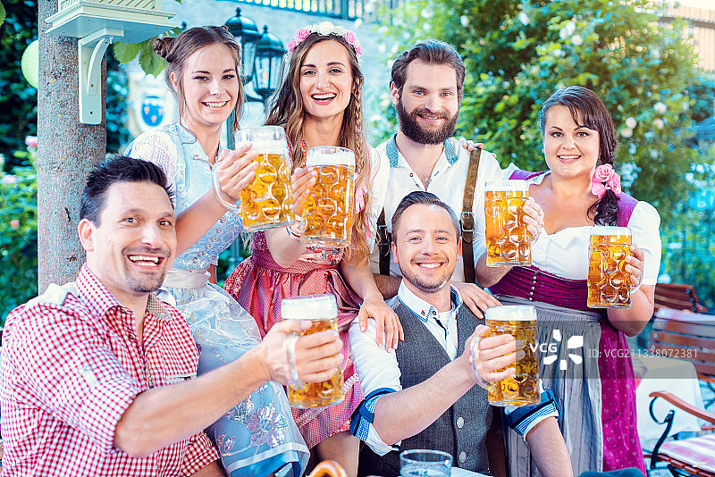 一群欢快的人喝着啤酒，拿着酒杯对着镜头图片素材