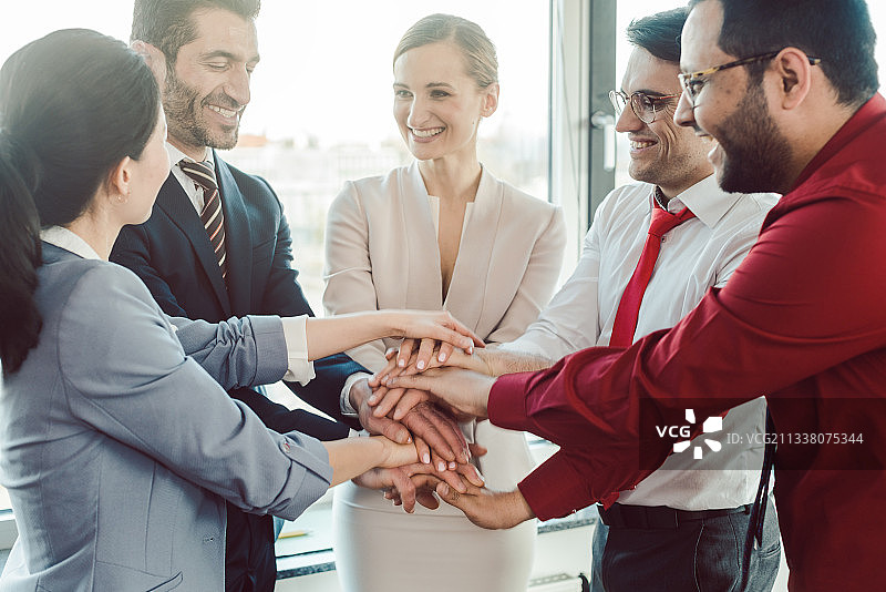 多元化团队的商务人士在启动会议上手把手地叠在一起图片素材