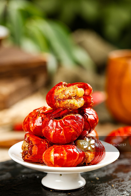 黑底上放着一盘麻辣虾球图片素材