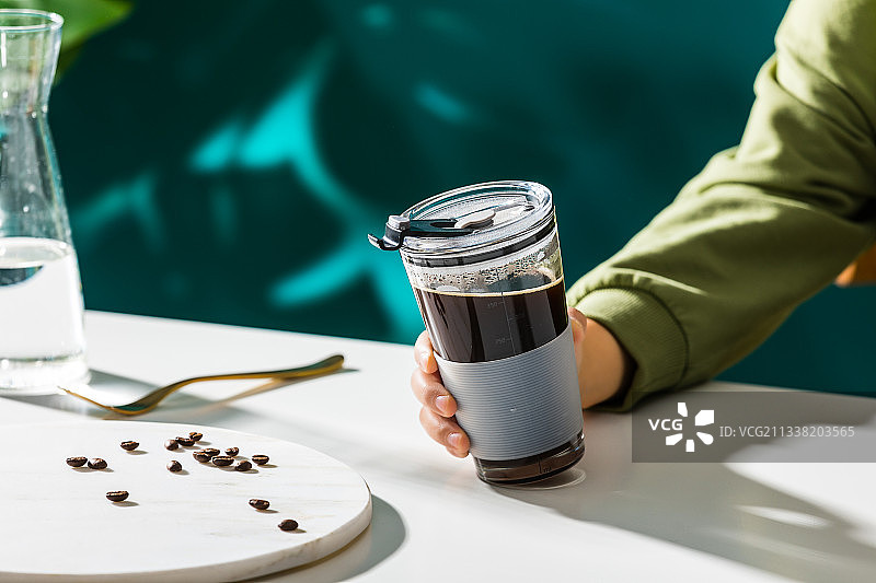 拿起桌子上的卡通吸管杯咖啡图片素材