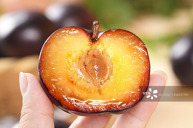 手拿切开的黑布林图片素材