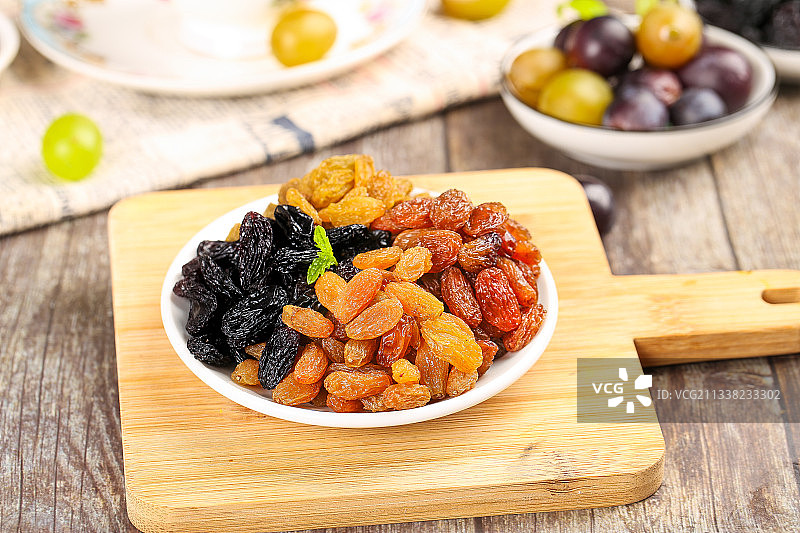 木底上放着一盘四色葡萄干图片素材