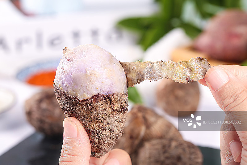 手拿剥皮的熟香芋图片素材