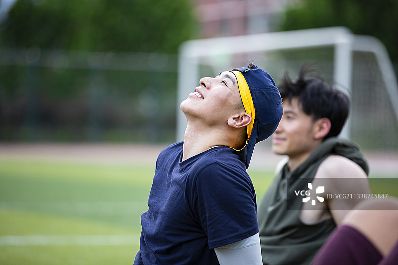 两个打篮球青年男子在学校操场做体能训练后休息图片素材