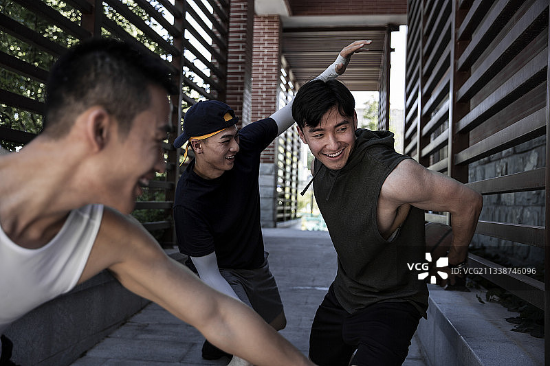 三个青年男子在学校走廊嬉戏练习篮球图片素材
