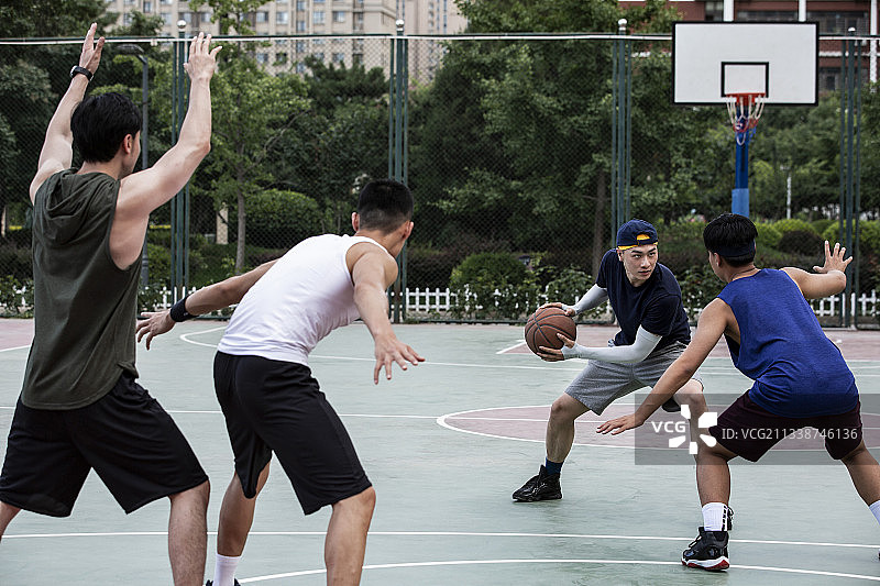 四个青年男子在学校篮球场打篮球比赛图片素材