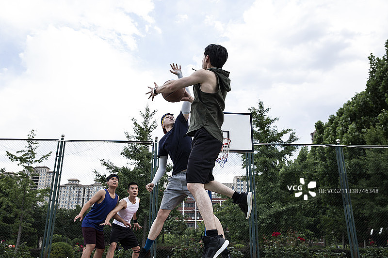 四个青年男子在学校篮球场打篮球比赛图片素材