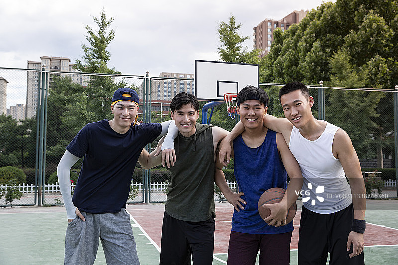 四个青年男子在学校篮球场打篮球比赛肖像图片素材