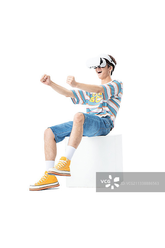 坐在木箱子上带着VR的年轻男生图片素材