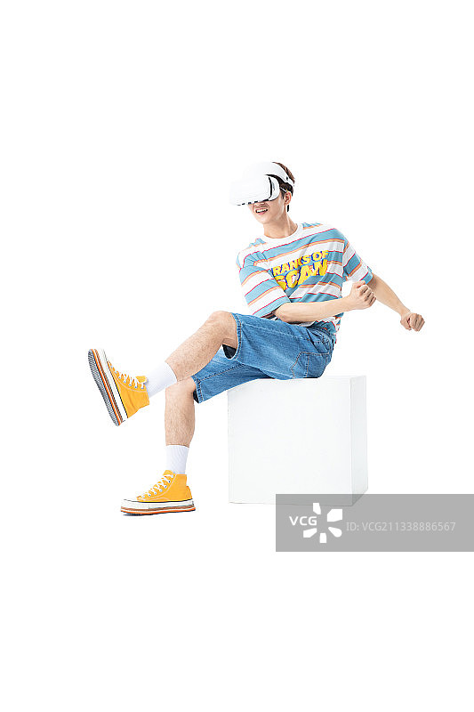 坐在木箱子上带着VR的年轻男生图片素材