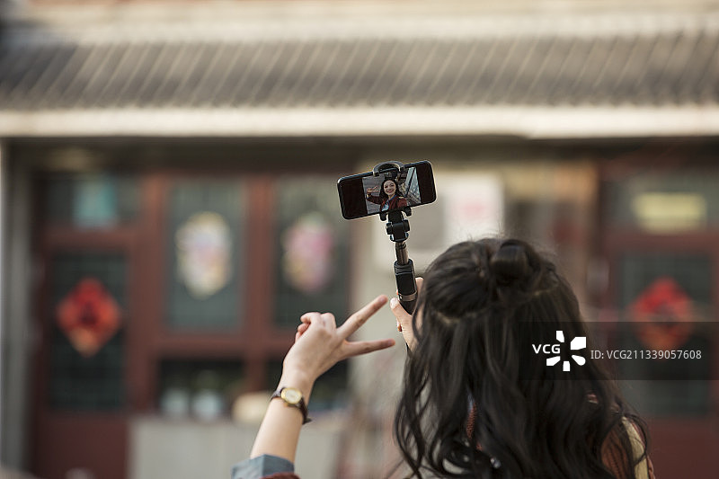 青年女子视频直播城市胡同旅行图片素材