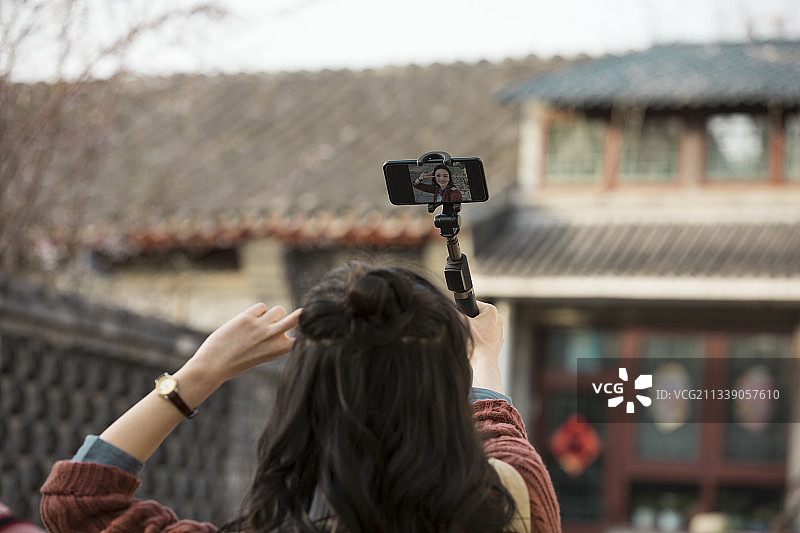 青年女子视频直播城市胡同旅行图片素材