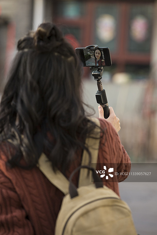 青年女子视频直播城市胡同旅行图片素材