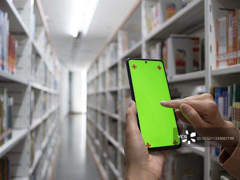在图书馆内用电子设备手机平板绿屏抠图图片素材