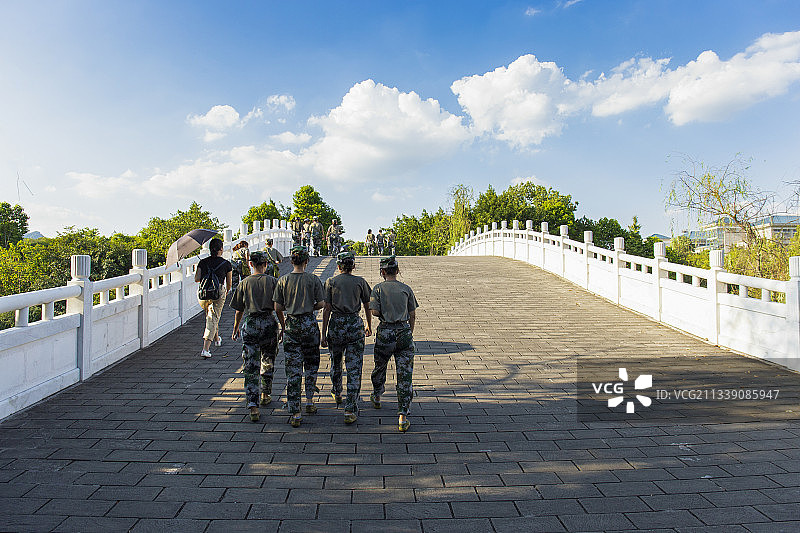 夏天，刚入的几个正在军训的大学生走在重庆师范大学的拱桥上图片素材