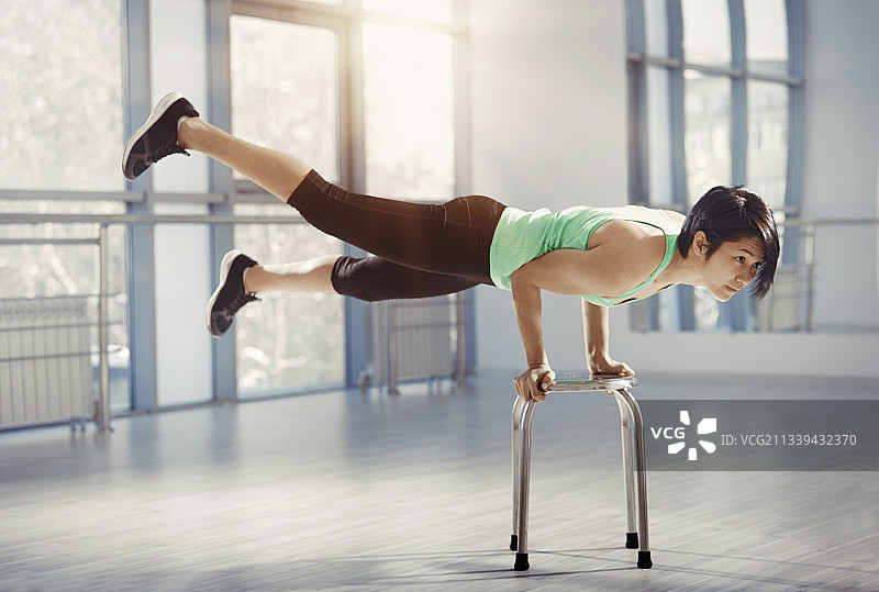 健身教练在椅子上做倒立图片素材