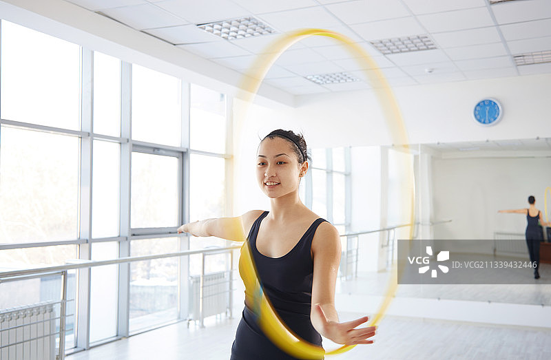 体操教练在明亮工作室展示呼啦圈舞图片素材