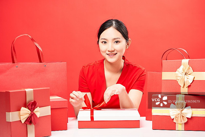 坐在很多礼盒前的女孩图片素材