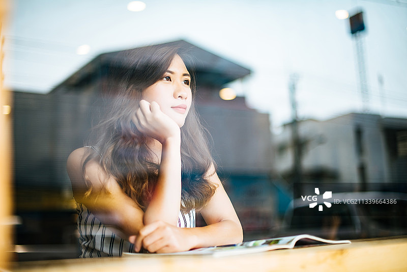 在咖啡馆里看杂志的女人图片素材
