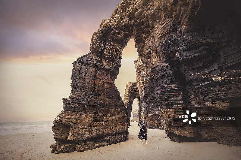 女子站在西班牙加利西亚里瓦德奥海滩日落时的背影图片素材