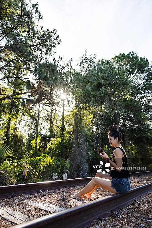 坐在铁轨上的女人，佛罗里达州盖恩斯维尔，美国图片素材