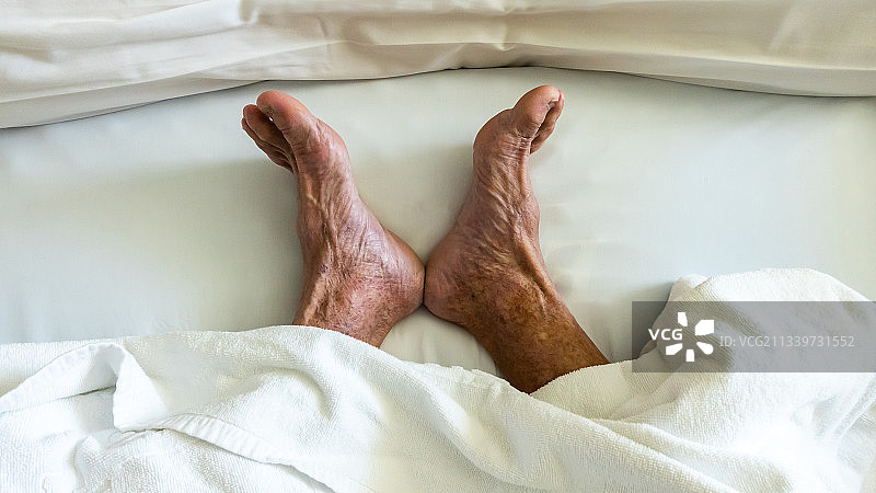 在家中床上放松的人的下半身图片素材