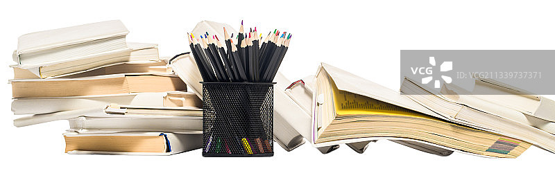 铅笔盒和成堆书籍中的彩色铅笔图片素材