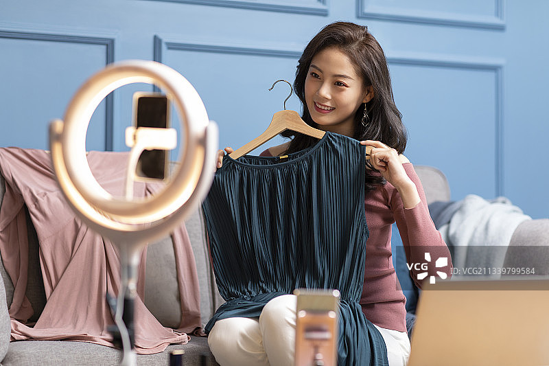 年轻女子在家直播卖衣服图片素材