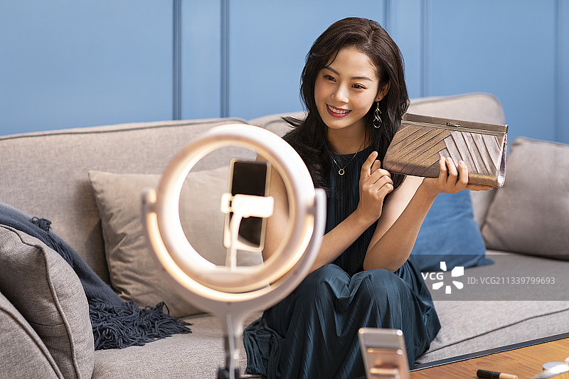 年轻女子在家直播卖时尚女包图片素材
