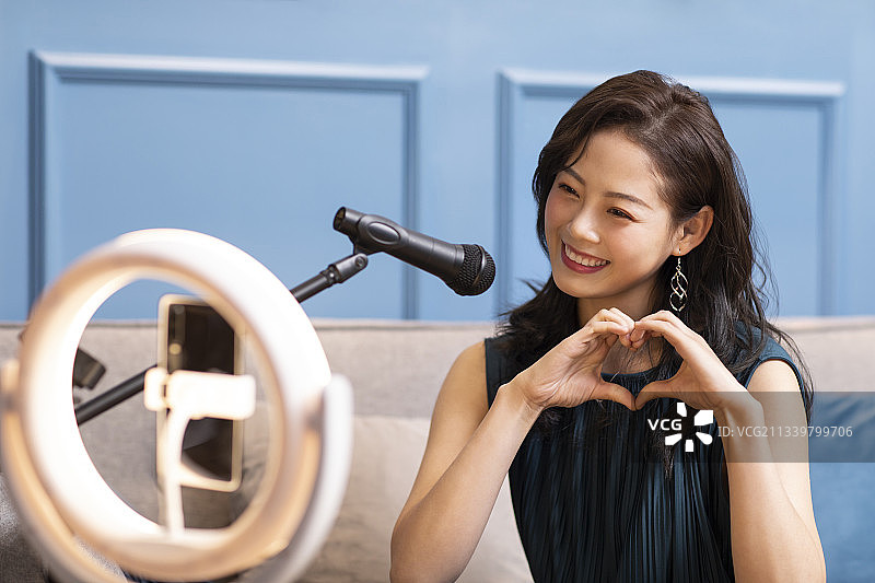 年轻女子在家直播唱歌图片素材