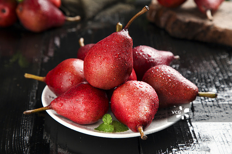 黑底上放着一盘陕西红啤梨图片素材