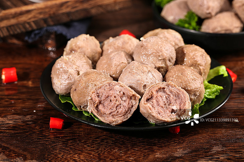 木底上放着一盘牛筋丸图片素材