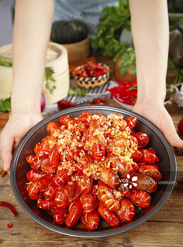 手里端着一盆蒜蓉小龙虾图片素材