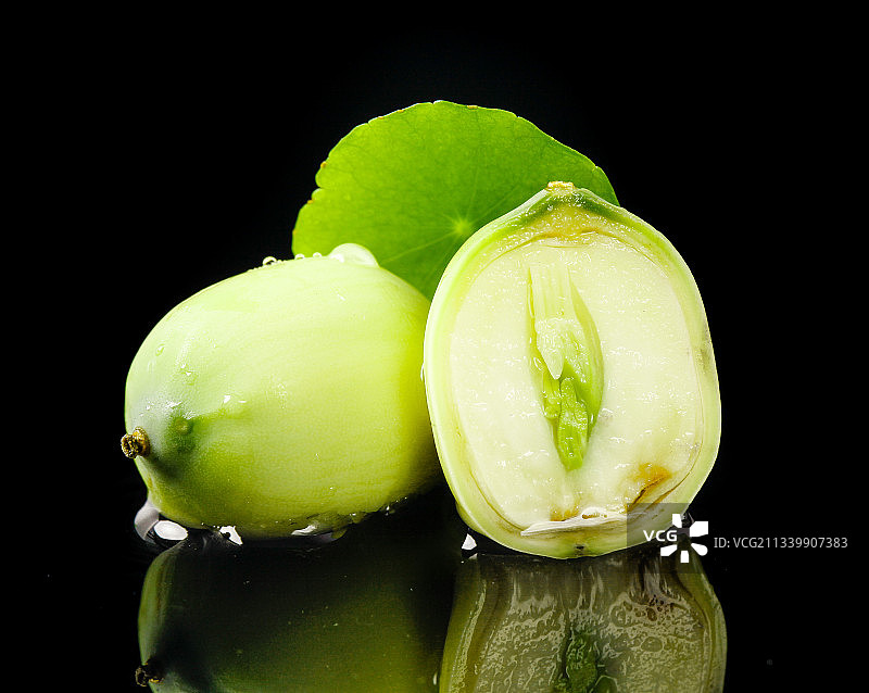 黑底上放着切开的水果莲子图片素材