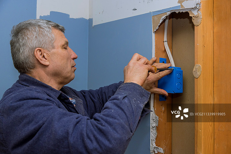 男人在家维修电源插座图片素材