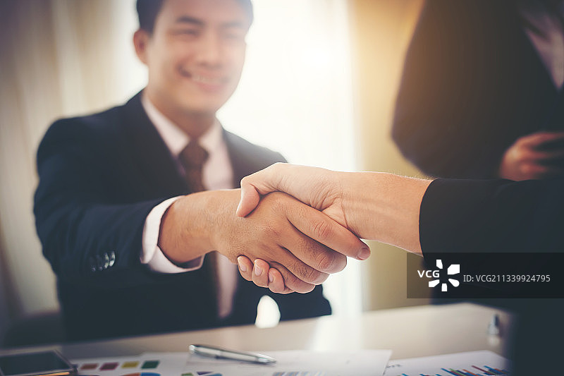 在办公室里握手的商人的身体中部图片素材