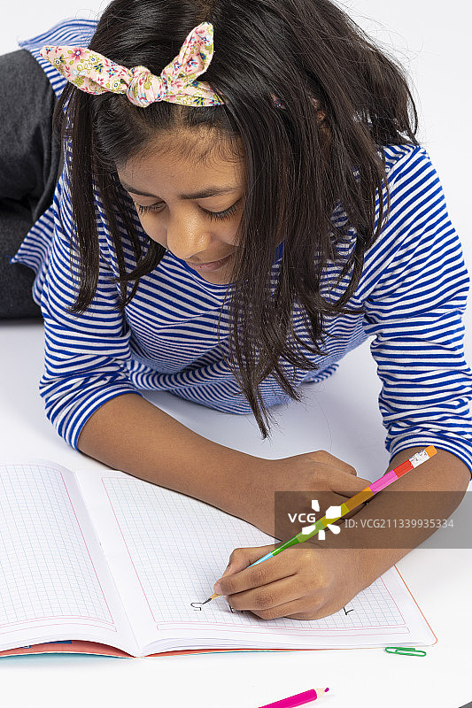 女孩躺在白色背景上读书图片素材