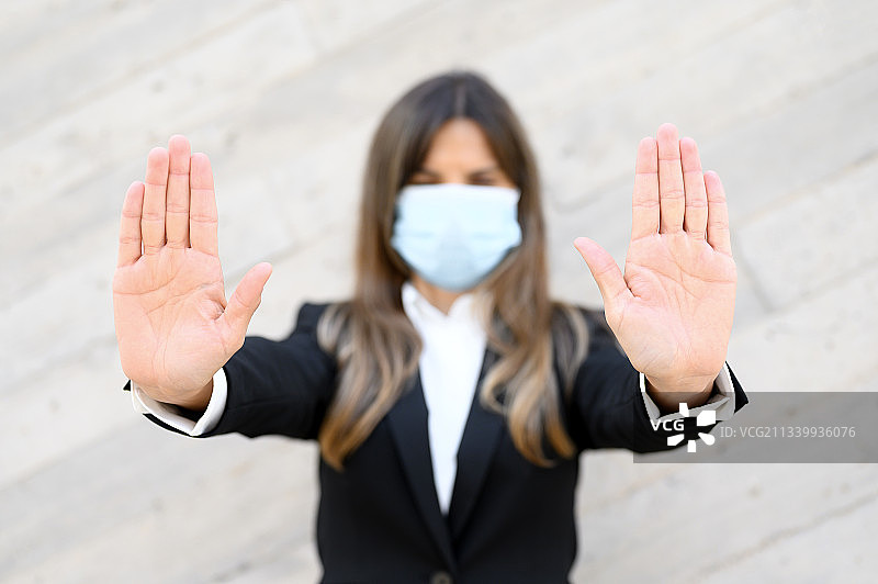 女商人靠墙站立，做停止手势图片素材