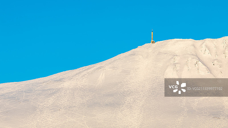 晴朗蓝天下白雪皑皑的山峰的低角度景观，挪威泰勒马克郡吕坎图片素材