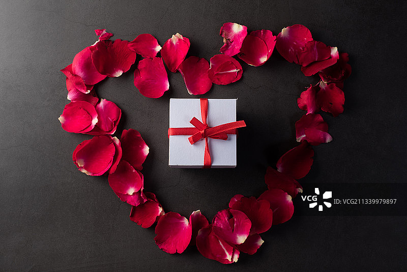 桌子上玫瑰花瓣和礼品盒的高角度视图图片素材