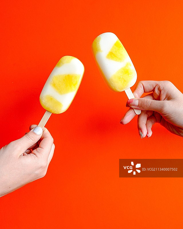 手持冰镇刨冰特写，橙色背景图片素材