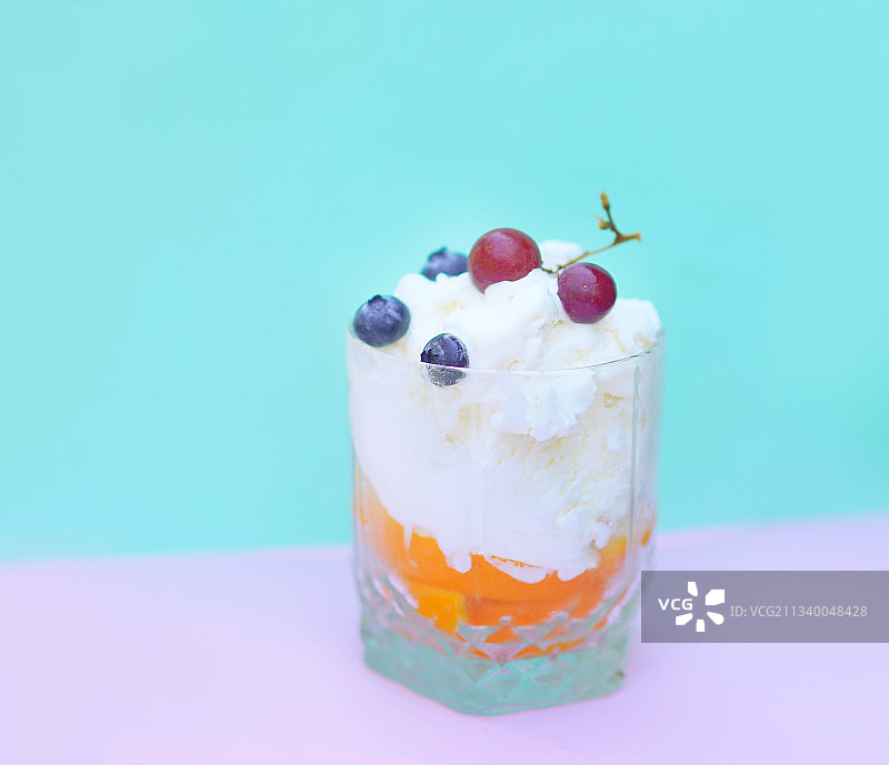 蓝色背景下玻璃杯中的冰淇淋特写图片素材