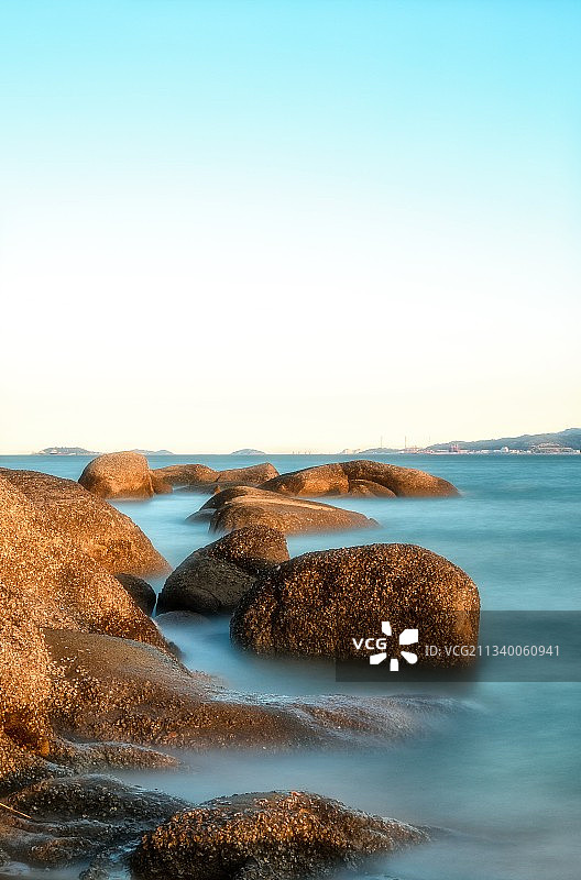 长曝光下的海岸礁石与雾状海面图片素材