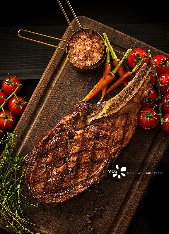 木质菜板上的海盐番茄百里香战斧牛排图片素材
