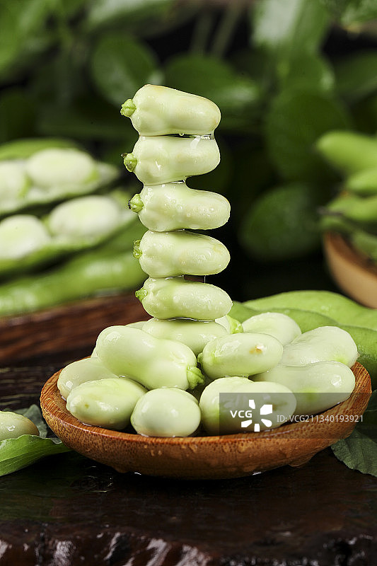 木底上放着剥壳的新鲜蚕豆图片素材