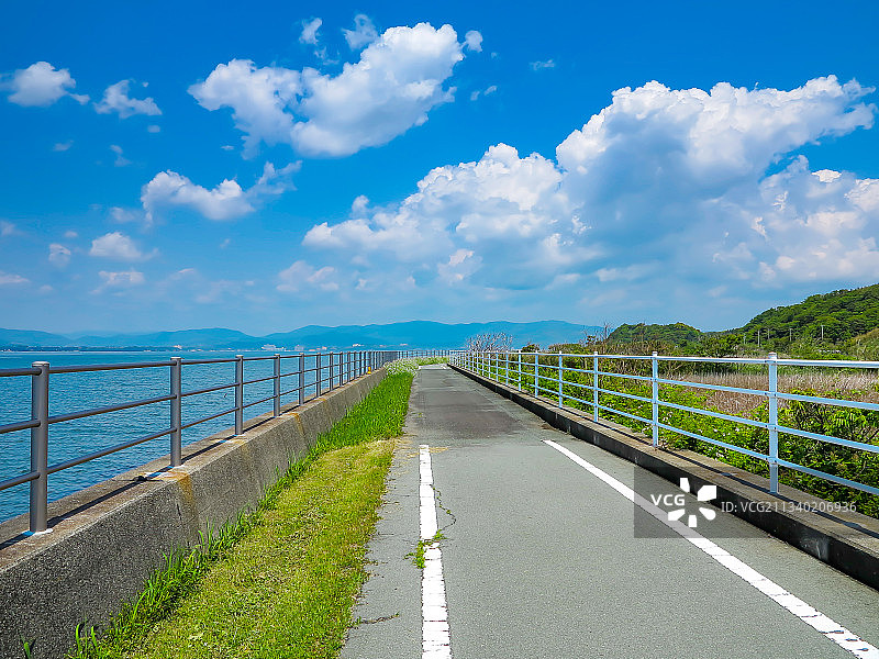 夏日，日本静冈滨名湖风和日丽，湖畔花朵与旅游车道图片素材