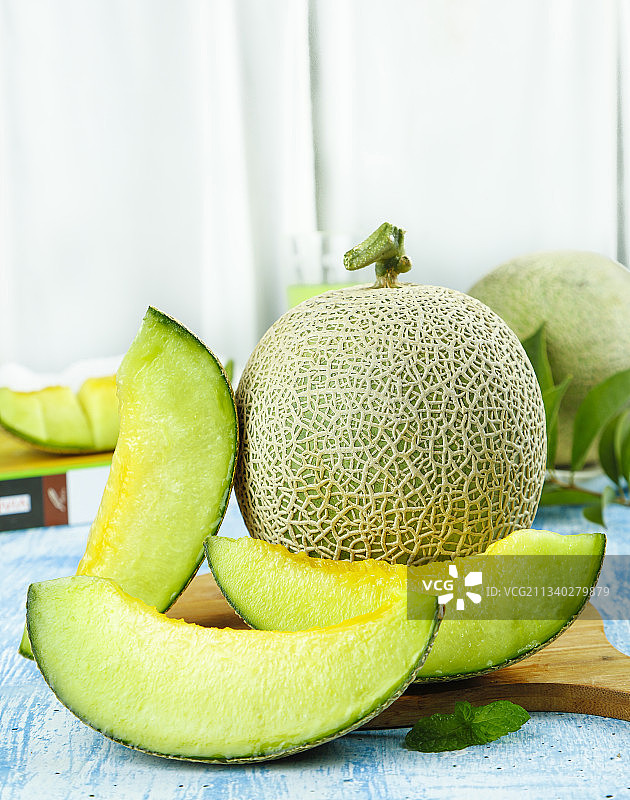 蓝底上放着切开的玫珑瓜图片素材