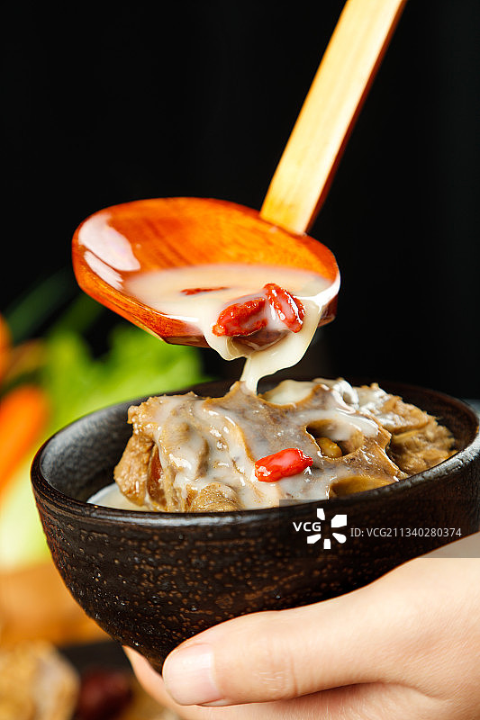 手里端着一碗羊蝎子汤图片素材